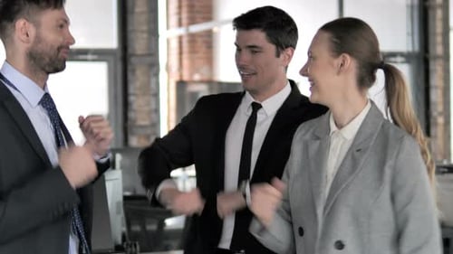 Three Business People Celebrating Success Together