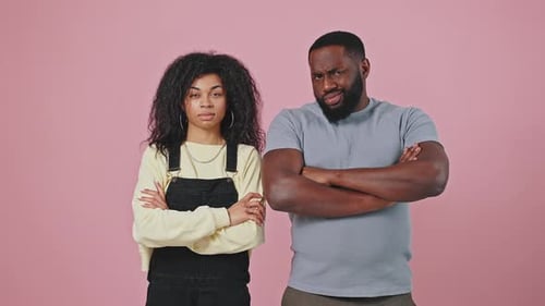 Skeptischer afroamerikanischer Mann und Frau schauen mit gekreuzten Händen in die Kamera und schütteln den Kopf und
