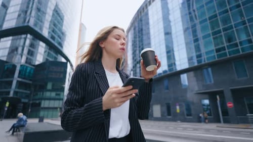 A Confident Corporate Office Woman Employee in Formal Dress Holding a Coffee Mug and Phone in Hands