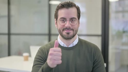 Man Gives Thumbs Up Gesture in Office