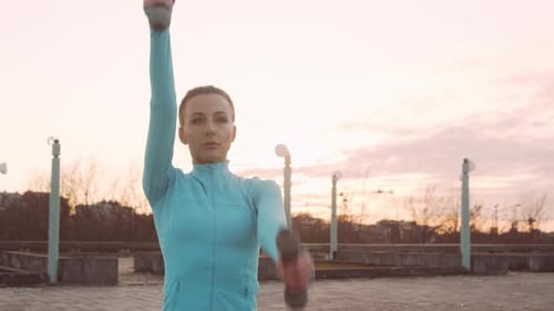 Woman Doing Arm Workouts with Dumbbells Outdoors