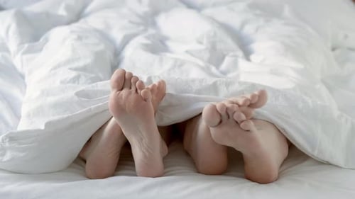 Passionate Loving Couple Having Sex Under White Blanket in Bedroom Close Up of Male and Female Feet