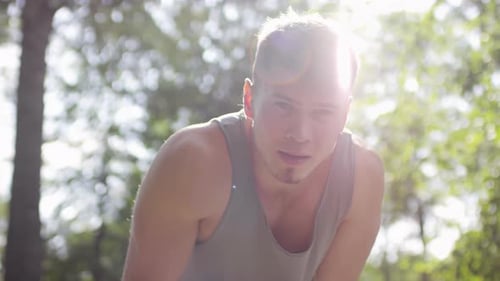 Young Tired Man Resting after Morning Run and Looking at Camera