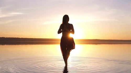 De belles images d'une femme à Sunset Beach faisant du yoga Asana Utthita Hasta Padagushthasana séjournant
