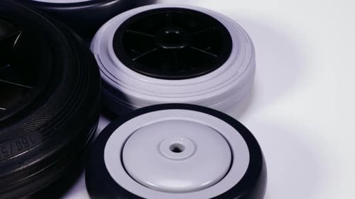 Plastic Wheels of Varying Size Rotating on White Surface