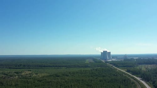 Smoking Cooling Towers at Nuclear Power Plant in Forest with Road. Aerial View