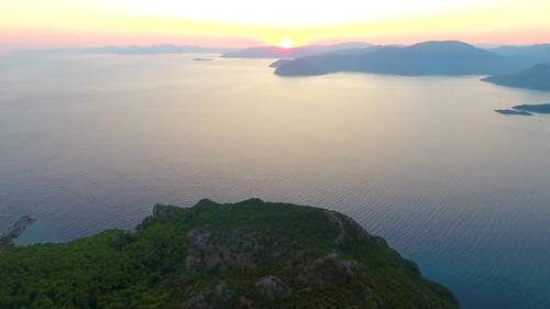 Amanecer de la mañana sobre colinas boscosas en la orilla del mar