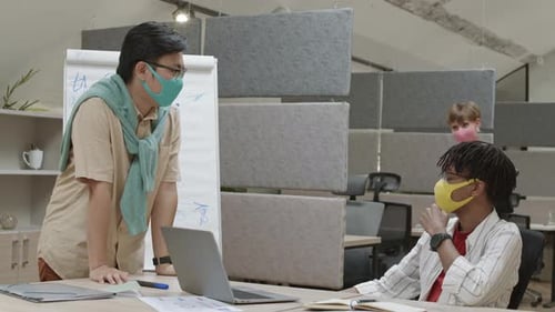 Female Manager Greeting Coworkers in Office