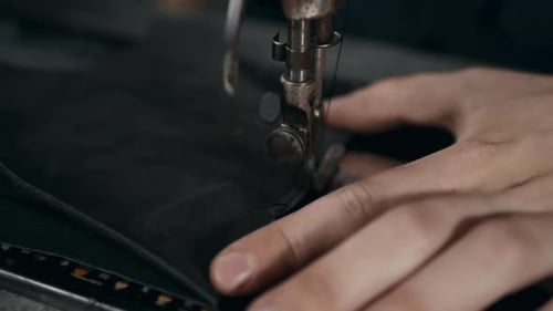 Hands Sewing Black Fabric with Sewing Machine