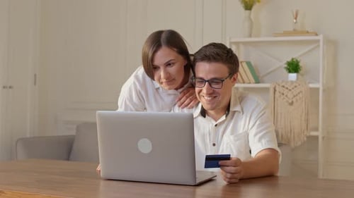 Couple Shops Online at Home with Laptop