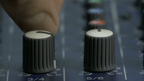 Dial Being Adjusted on a Mixing Board
