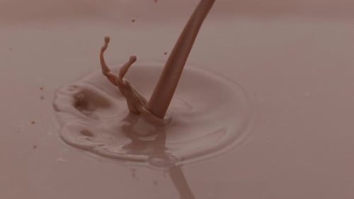 Schokoladenmilch gießt und spritzt in Zeitlupe; aufgenommen auf Phantom Flex 4K bei 1000 fps