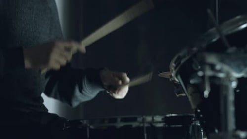 man sits down to play the drum set