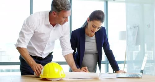 Architects working together on blueprint in a modern office
