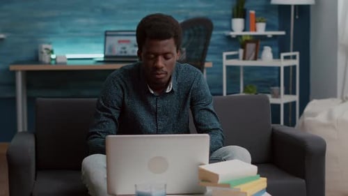 Young Adult Communicating on Laptop in Living Room