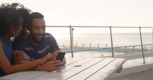 Couple using mobile phone in the beach 4k