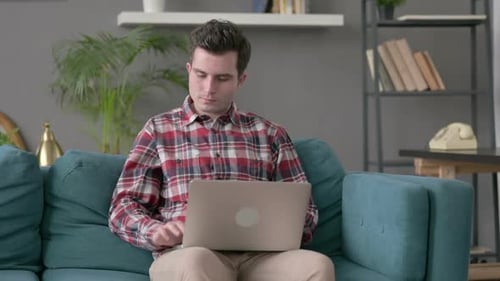 Man Working on Laptop Gives Thumbs Down