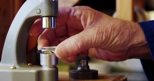 Horloger réparant une montre sur une machine