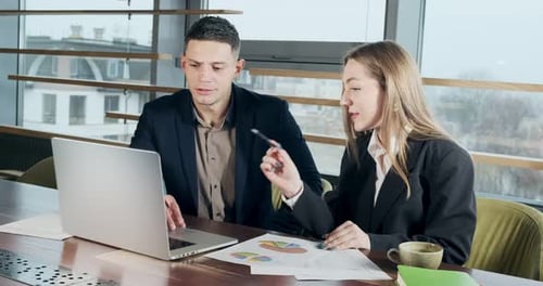 Man and a Woman Discussing Work in the Brightly Lit Modern Office. Concerned Male and Female Working