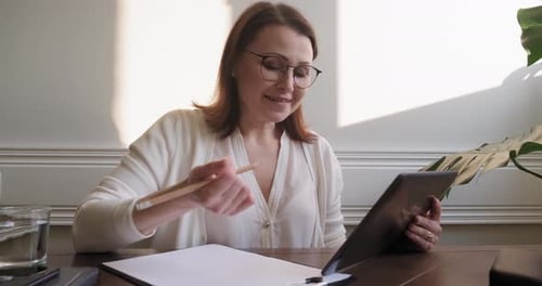 Woman Working at Home with Tablet and Pencil