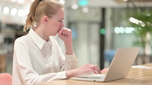 Unwell Woman Coughing While Working on Laptop