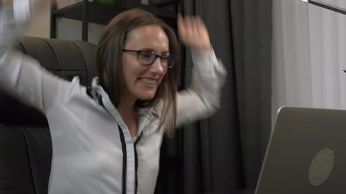Excited Woman Celebrates Success at Her Laptop