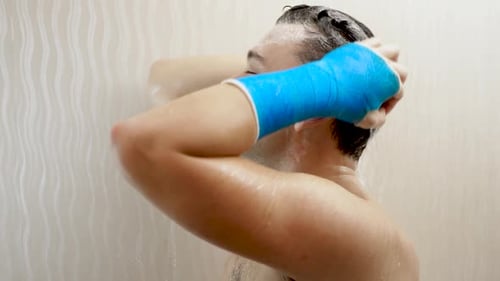 Man with Arm Cast Washing Hair in Shower