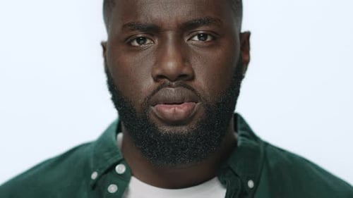 Portrait of Thoughtful African American Guy Looking at Camera in Studio
