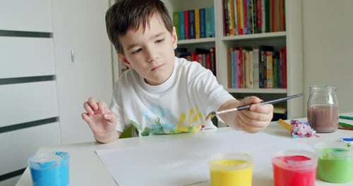 Young Boy Painting with Watercolors at Home