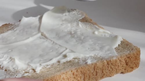 Spreading Cream Cheese on Bread with Spoon