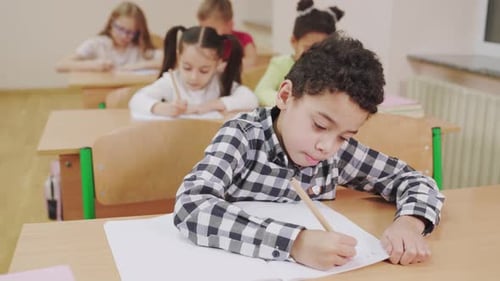 Children Working Quietly at Desks in Classroom