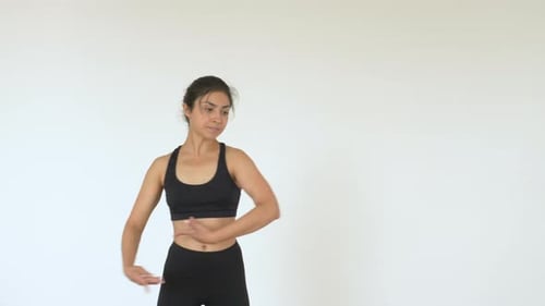 A young Indian Ballerina trains in a Gym, does a Spinning exercise, And Is dressed in a Black Top