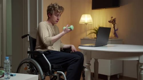 A Sporty Disabled Man is Making an Exercise with Dumbbells