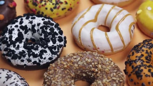 Verschiedene Donuts mit orangefarbenem Hintergrund