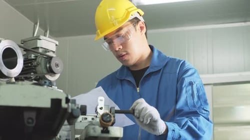 Asian mechanical technicians workers working on milling and operating the machine in factory.