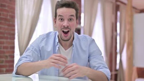 Excited Young Man Reacts with Laughter and Joy