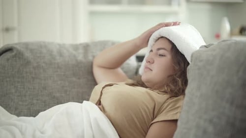 Side View of Ill Plus-size Caucasian Woman Taking Pill in Blister Pack From Hand of Unrecognizable