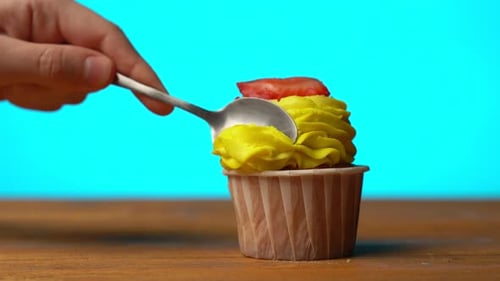 Cupcake with Strawberry Slice Eaten with Spoon