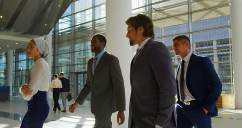 Mixed-race business people walking together in the lobby at office 4k