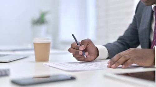 Close Up of African Businessman Working on Financial Documents in Office