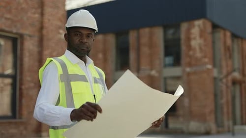 Portrait of Competent Engineer with Building Project in Hand