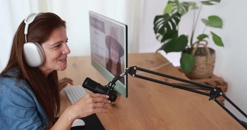 Woman Chatting into Microphone at Computer