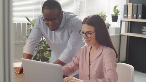 Multiethnic Office Workers Discussing Project on Laptop