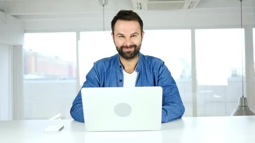 Smiling Handsome Man Sitting in Office Positive