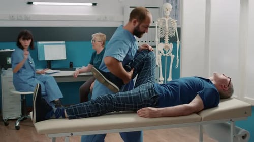 Man Receives Leg Stretching Physical Therapy at Hospital