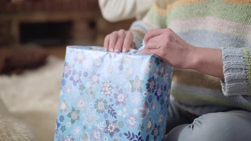 Hands Unwrapping a Gift Revealing Another Box
