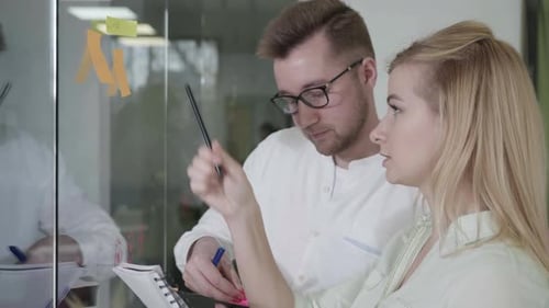Man and Woman Brainstorming in an Office