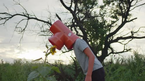 Child with Pipe on Head in Field at Sunset