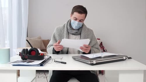 Young Adult with Mask Working at Desk