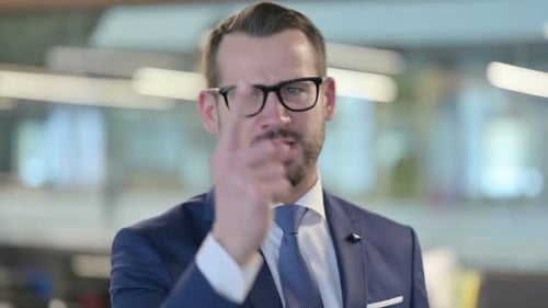Man in Suit Gesturing Assertively in an Office